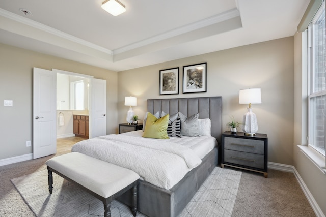 carpeted bedroom with multiple windows, crown molding, ensuite bathroom, and a tray ceiling