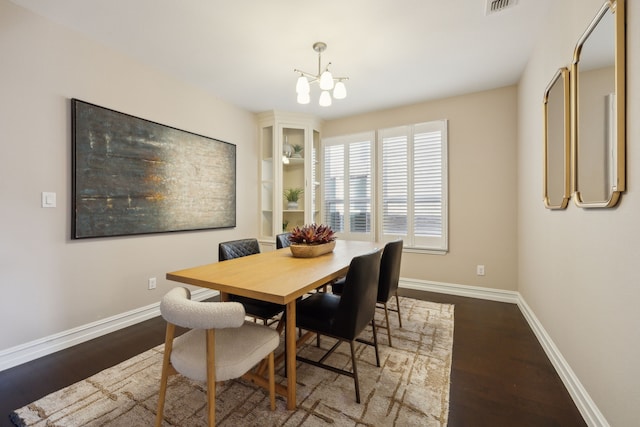 dining space with wood-type flooring and a chandelier