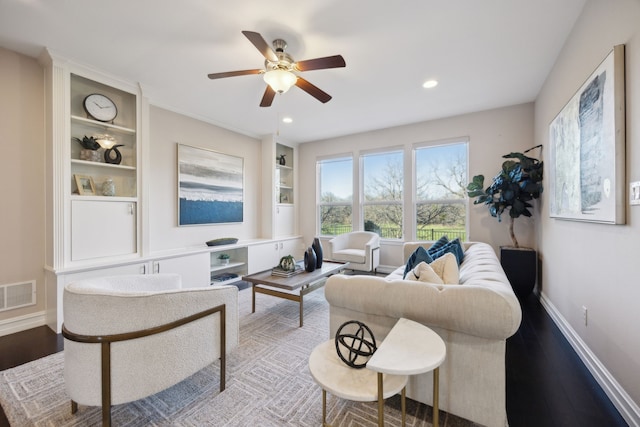 living room with built in features, light hardwood / wood-style floors, and ceiling fan