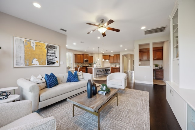 living room with dark hardwood / wood-style floors and ceiling fan