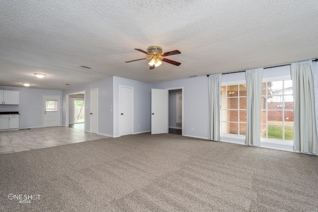 unfurnished living room featuring ceiling fan, light carpet, and a textured ceiling