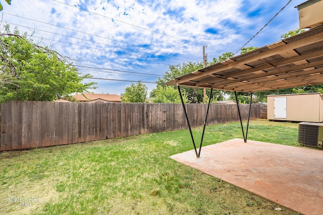 view of yard featuring a storage unit, cooling unit, and a patio area