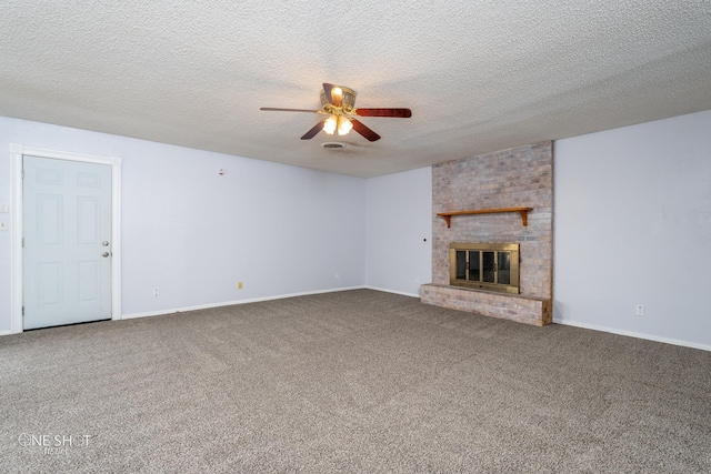 unfurnished living room with ceiling fan, a brick fireplace, carpet, and a textured ceiling