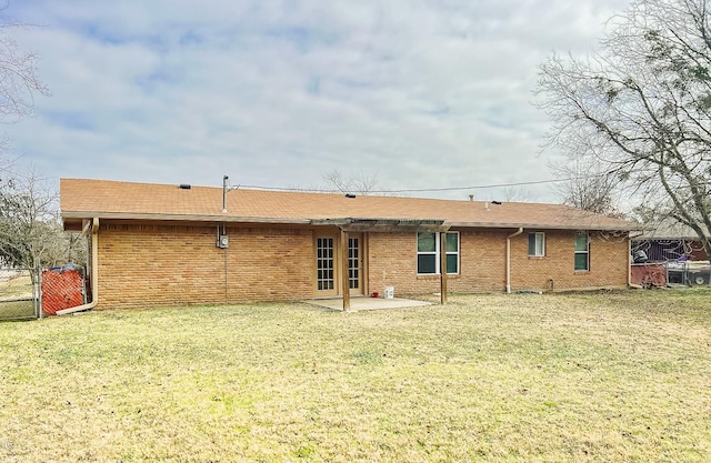 rear view of property with a patio and a lawn