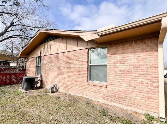 view of side of home featuring a yard and central AC unit