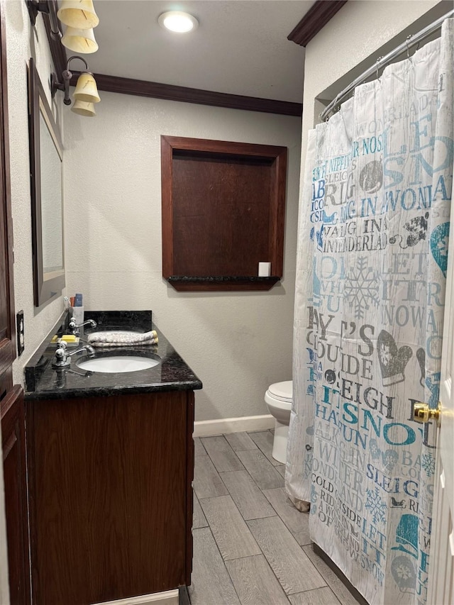 bathroom featuring vanity, crown molding, and toilet