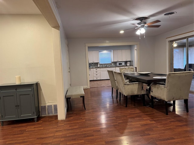 dining area with ceiling fan and dark hardwood / wood-style flooring