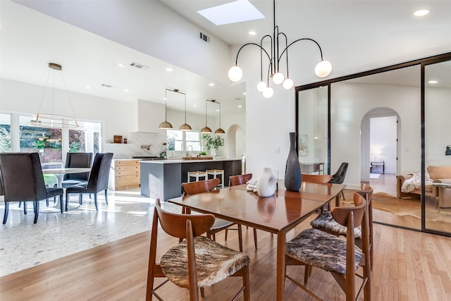 dining area featuring an inviting chandelier, light hardwood / wood-style flooring, and a wealth of natural light