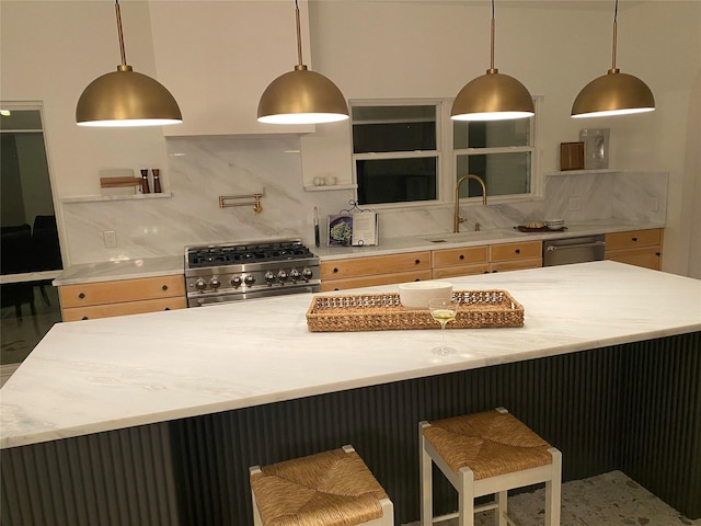 kitchen featuring appliances with stainless steel finishes, decorative light fixtures, sink, and backsplash