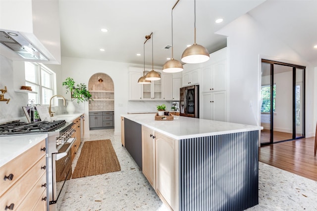 kitchen featuring white cabinetry, hanging light fixtures, appliances with stainless steel finishes, a kitchen island, and exhaust hood