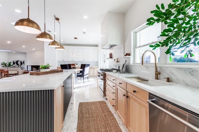 kitchen featuring sink, appliances with stainless steel finishes, hanging light fixtures, a spacious island, and light brown cabinetry