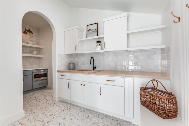 kitchen with white cabinetry, sink, and backsplash