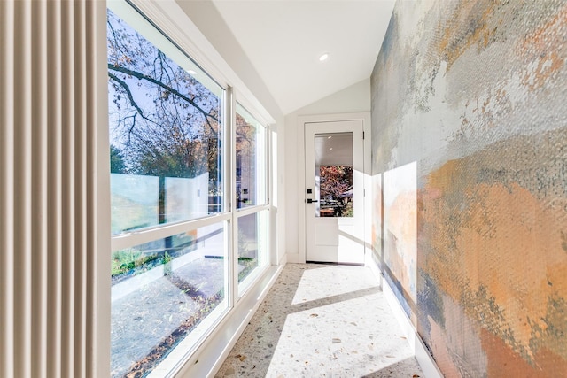 corridor featuring vaulted ceiling and a wealth of natural light