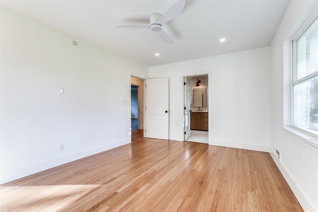 unfurnished bedroom with ensuite bath, ceiling fan, and light wood-type flooring