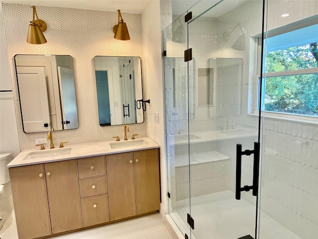 bathroom featuring vanity, toilet, backsplash, and walk in shower