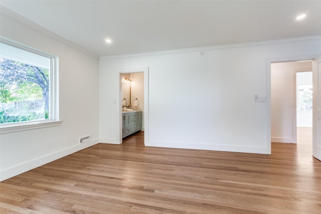 unfurnished room featuring ornamental molding and light wood-type flooring