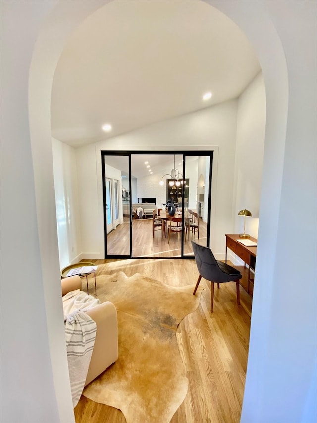 interior space featuring lofted ceiling and light hardwood / wood-style flooring