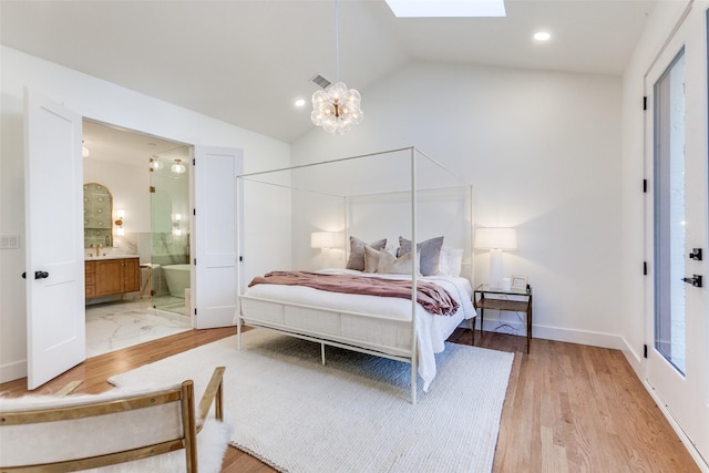 bedroom with sink, an inviting chandelier, lofted ceiling with skylight, ensuite bathroom, and light hardwood / wood-style floors