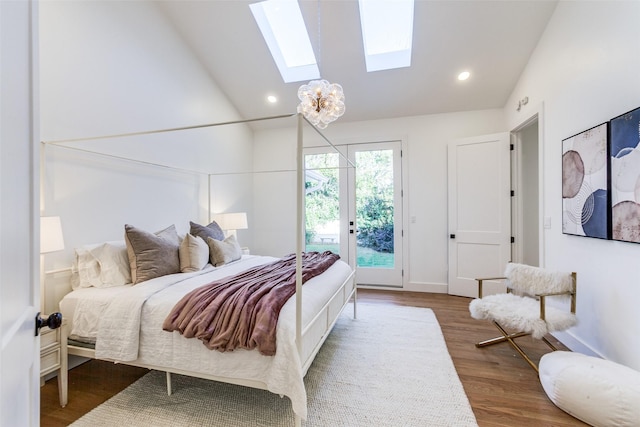 bedroom featuring dark hardwood / wood-style floors, lofted ceiling with skylight, and access to outside