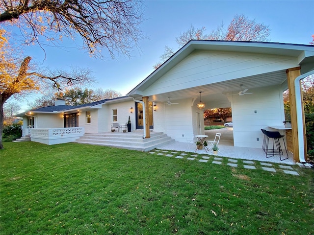 back of property with a patio area, ceiling fan, and a lawn