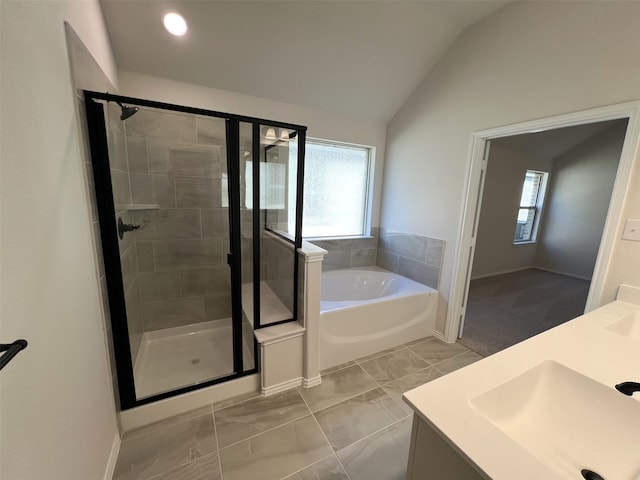 bathroom with independent shower and bath, vanity, lofted ceiling, and a wealth of natural light