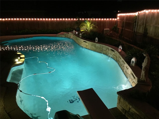 pool at night with fence and a fenced in pool