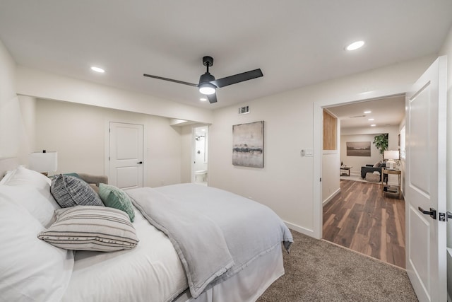 bedroom with dark hardwood / wood-style flooring, connected bathroom, and ceiling fan