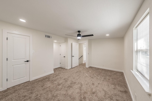 carpeted spare room with ceiling fan