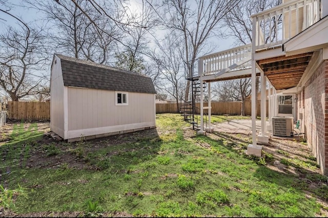 view of yard featuring central AC unit and a storage shed