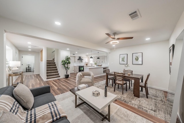 living room with light hardwood / wood-style flooring and ceiling fan