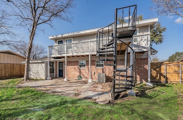 rear view of property featuring central AC, a patio area, and a lawn