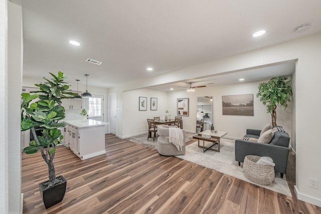 living room featuring wood-type flooring and ceiling fan