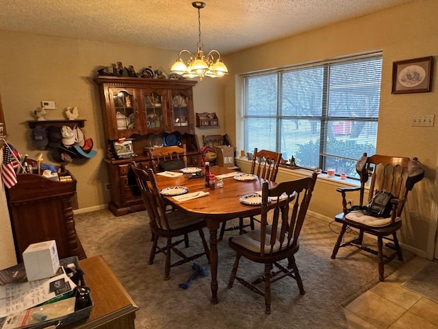 dining room with an inviting chandelier, tile patterned flooring, and a textured ceiling