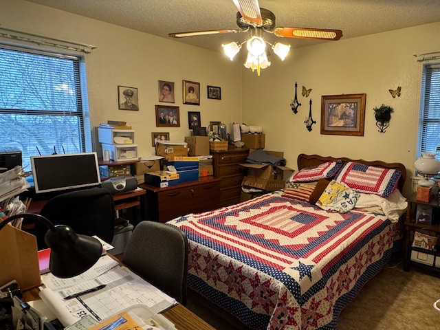 bedroom featuring ceiling fan, carpet, and a textured ceiling