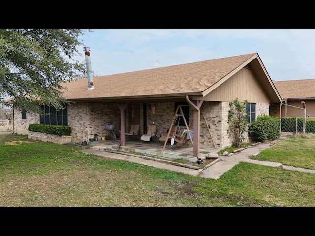 back of house with a patio and a lawn