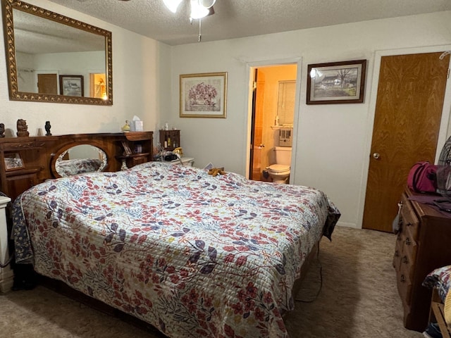 carpeted bedroom featuring ceiling fan, a textured ceiling, and ensuite bath