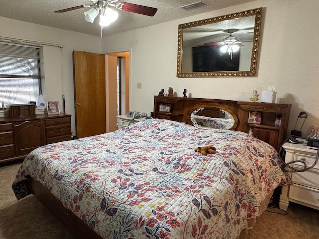 carpeted bedroom with ceiling fan and a textured ceiling