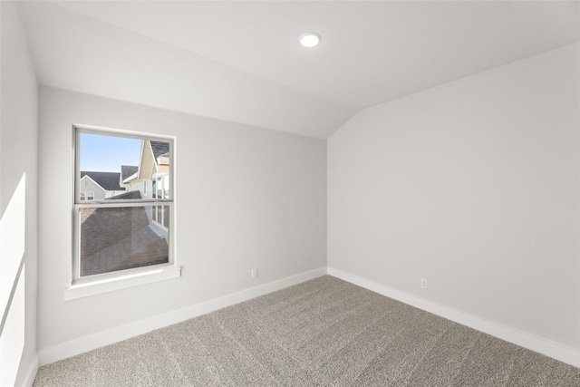 unfurnished room featuring lofted ceiling and carpet floors