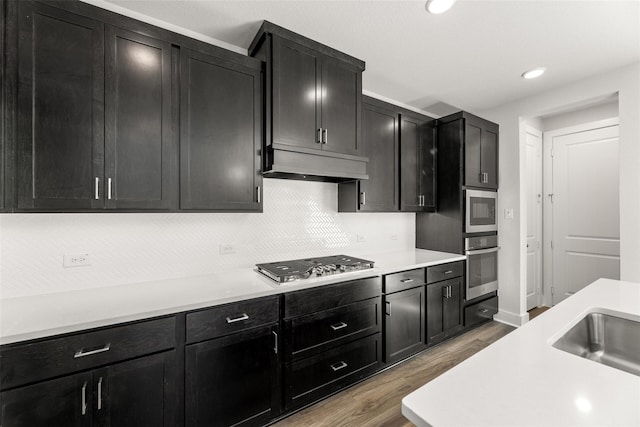 kitchen featuring tasteful backsplash, appliances with stainless steel finishes, sink, and light hardwood / wood-style floors