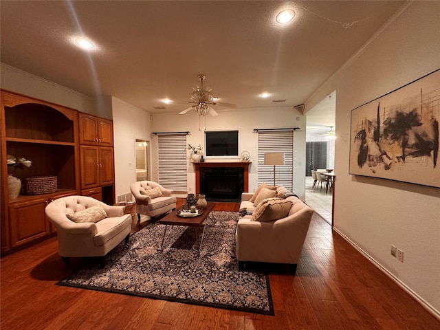 living room featuring wood-type flooring, ornamental molding, and ceiling fan