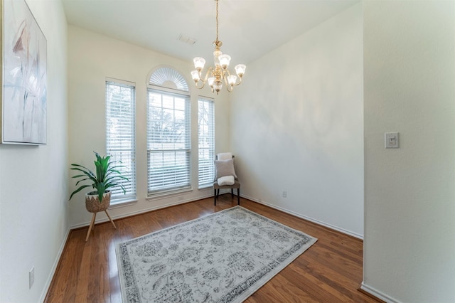 sitting room featuring baseboards, wood finished floors, visible vents, and an inviting chandelier