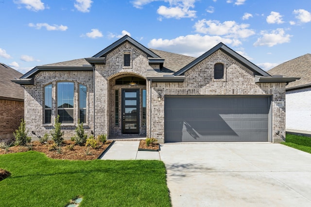 french country inspired facade with a garage and a front lawn