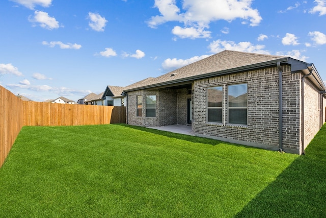 rear view of house with a yard and a patio area