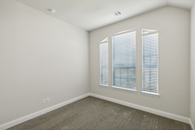 carpeted spare room featuring lofted ceiling