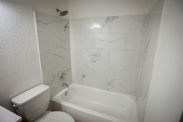 bathroom with tiled shower / bath combo and toilet