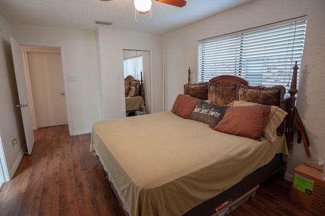 bedroom with dark hardwood / wood-style floors, a closet, and ceiling fan