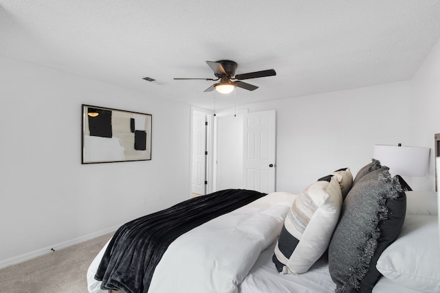 bedroom with light carpet, a textured ceiling, and ceiling fan