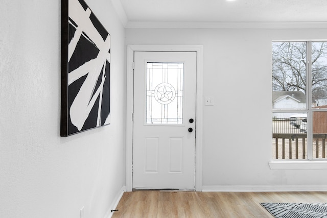 entrance foyer featuring ornamental molding and light hardwood / wood-style flooring