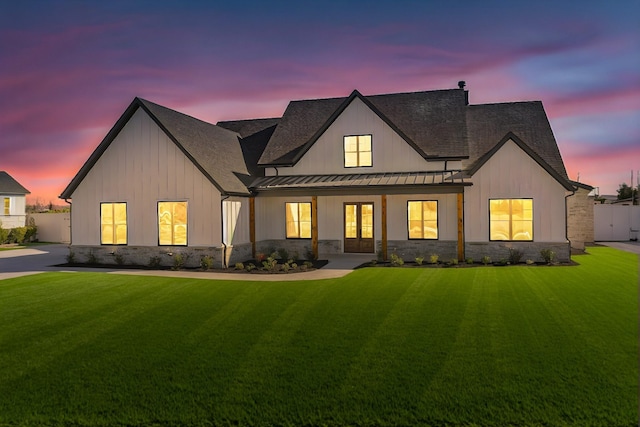 back house at dusk with a lawn