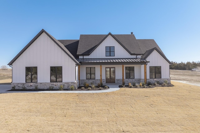 modern farmhouse style home with a porch and a front yard